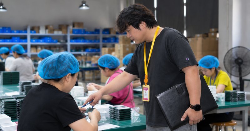 検品ラインでスタッフに品質を指導する日本人マネージャー