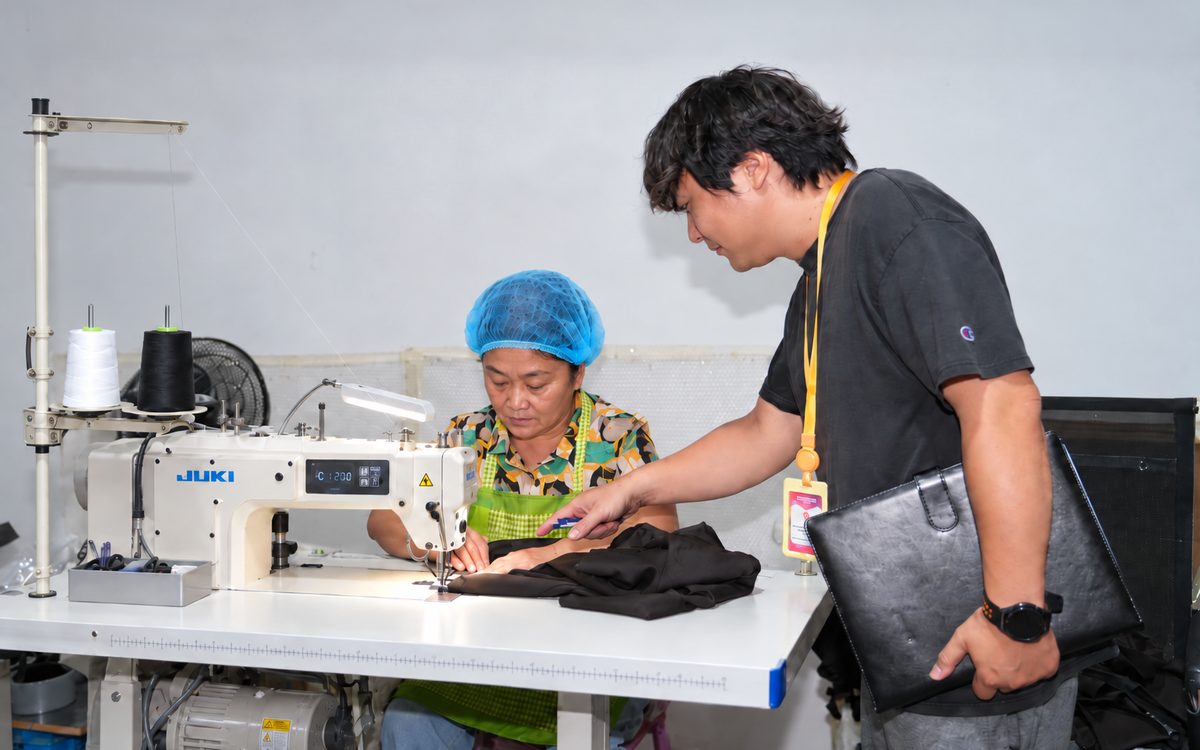 縫製の現場で作業を確認する日本人マネージャー